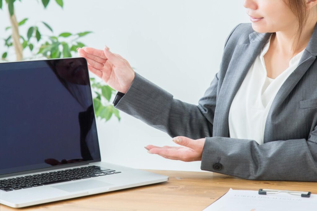 女性社員がパソコンを使って説明をしている